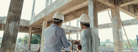Behind Civil engineer team meeting, discussing plan construction in blueprint at construction site. Teamwork discussing at workplace.の写真素材