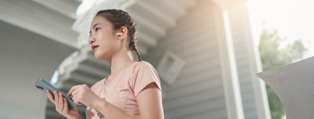 Asian woman athlete with earphones for music, radio or podcast for motivation. Fitness, energy and athlete runner doing outdoor cardio workout for good health.の写真素材