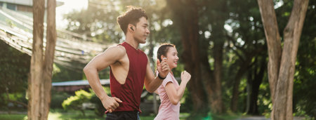 Two Asian young athlete man and woman in sportswear jogging exercise in park outdoor. Together young couple running outdoor in the morning. Healthy exercise concept.の写真素材
