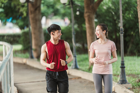 Two Asian young athlete man and woman in sportswear jogging exercise in park outdoor. Together young couple running outdoor in the morning. Healthy exercise concept.の写真素材