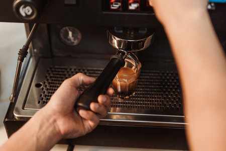 Top view, Hand of barista making coffee espresso pouring from espresso machine to cup. Espresso shot, Coffee making concept.の写真素材