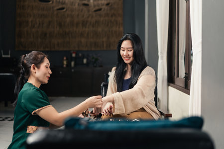 Asian Woman Spa Receptionist Assisting and present a Customer in Selecting essential oils.の写真素材
