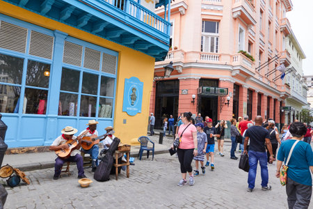 Cheerful street musicians playing on a street outdoors and people watching in Cubaのeditorial素材