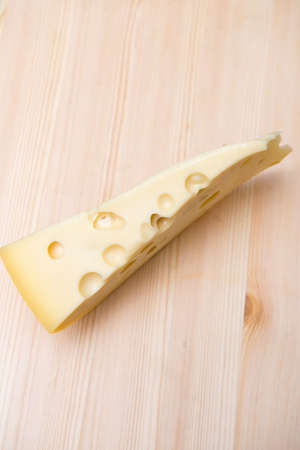 a big chunk of good cheese on a wooden surfaceの写真素材