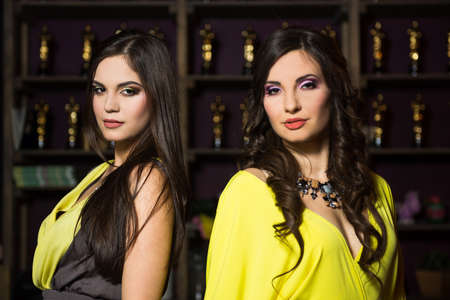 two beautiful girl in yellow evening dressesの写真素材