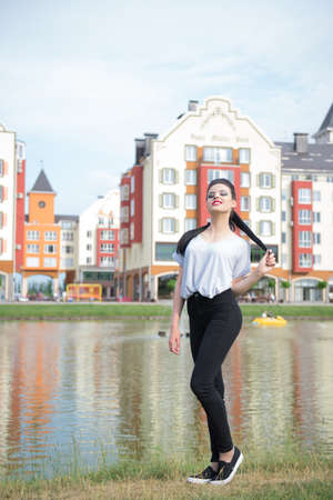 Beautiful girl on the shore of beautiful lake in a beautiful villageの写真素材