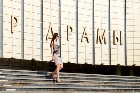 Beautiful girl in white blue dress walks in the evening in the setting sunの写真素材