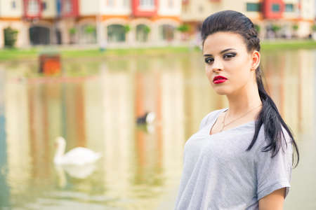 Beautiful girl on the shore of beautiful lake in a beautiful villageの写真素材