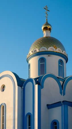 ponoramnaya new beautiful church with the golden dome is illuminated by the morning sunの写真素材