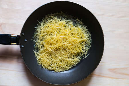 noodles in a pan before frying in oilの写真素材