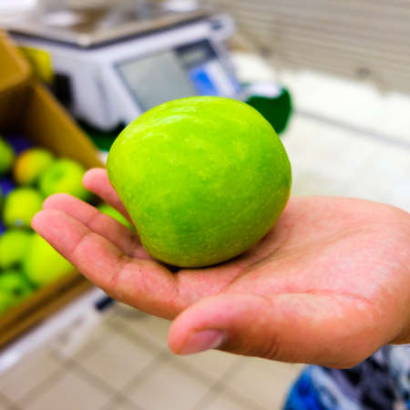 man holding an apple in his hand at the mallの写真素材