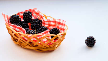 Mix of fresh berries in a basket on rustic wooden backgroundの写真素材