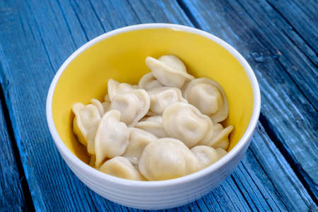 beautiful delicious dumplings in a yellow plate on a blue backgroundの写真素材