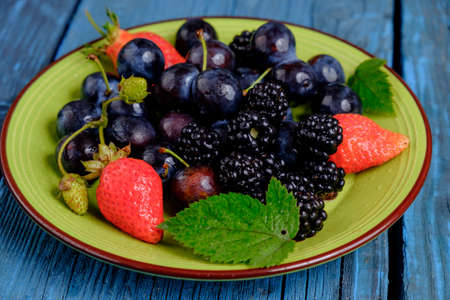 delicious berry fruit mix on a blue wooden backgroundの写真素材