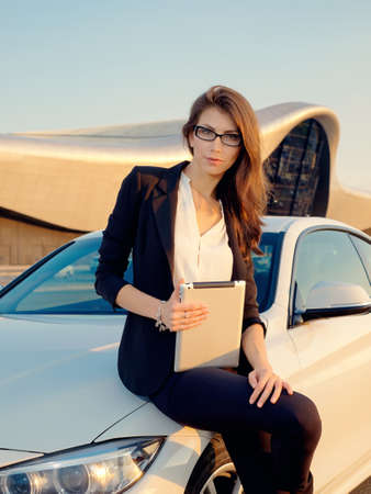 Business woman posing at the mall with Divays in hand and without, in the beautiful setting sunの写真素材