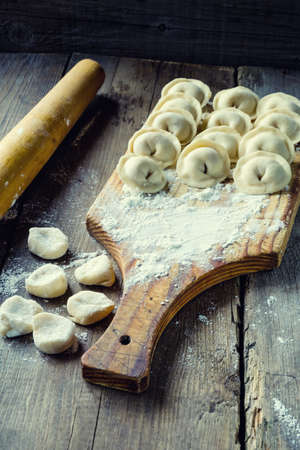 Modeling delicious Russian dumplings. Dumplings in flour on the board.の写真素材