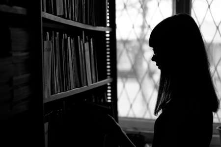 Young beautiful Russian girl is working on a major project in the library.の写真素材