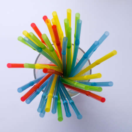 Multicolored tubes for cocktails on a white background illuminated by the light from the window.の写真素材