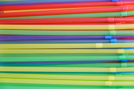 Multicolored tubes for cocktails on a white background illuminated by the light from the window.の写真素材