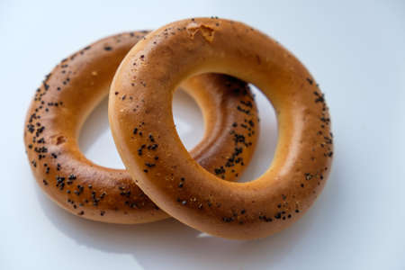 Delicious fresh bagels on a white table, illuminated by the light from the window.の写真素材