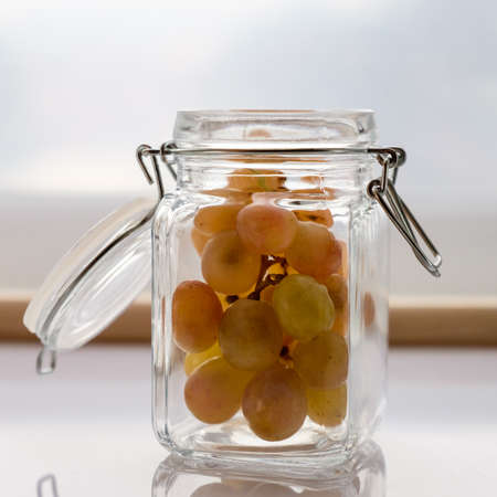 Grapes in a nice bowl on a white background with light from the window.の写真素材