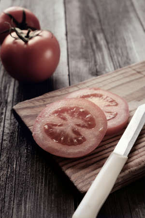 Delicious vintage tomatoes shot on a tree with the light from the window.