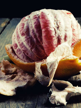 Tasty orange grapefruit on the table of boards, illuminated red light basement.の写真素材
