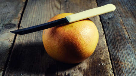 Tasty orange grapefruit on the table of boards, illuminated red light basement.の写真素材