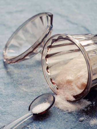 Food salt in plastic jar on the stone background.の写真素材