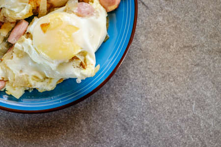 Fried eggs in blue plate on a stone backgroundの写真素材