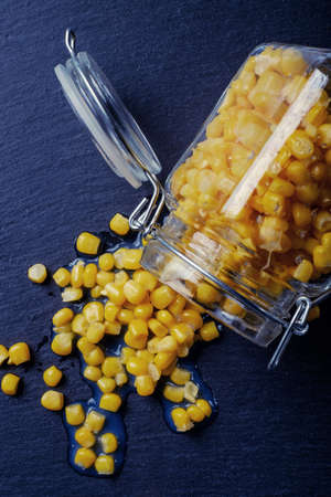Delicious, fresh corn in a glass jar, shot on a black board in the studio.の写真素材