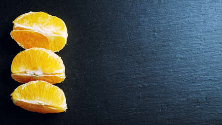 Citrus fruits on a wooden board on a dark backgroundの写真素材