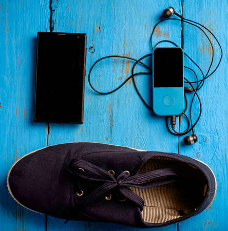 Sneakers and earphones on wooden table, top viewの写真素材
