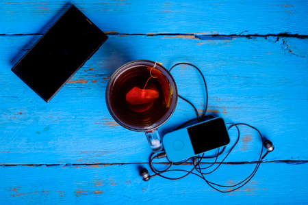 Top view notebook pen glasses vintage clock and mobile phone on tableの写真素材