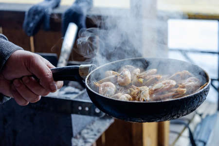 Preparation of delicious shrimp in the pan outdoors in the gazebo.の写真素材