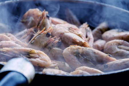 Preparation of delicious shrimp in the pan outdoors in the gazebo.の写真素材