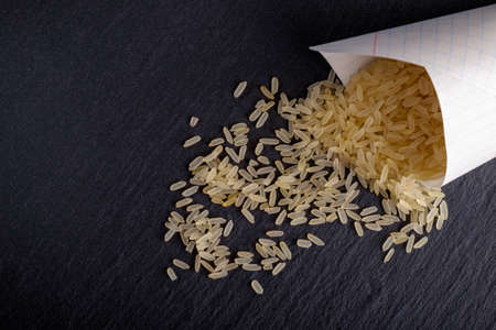 Rice in bags on the black stone board. lit studio lights.の写真素材