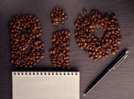 bean coffee and a notebook on dark slate background, lit studio lightの写真素材