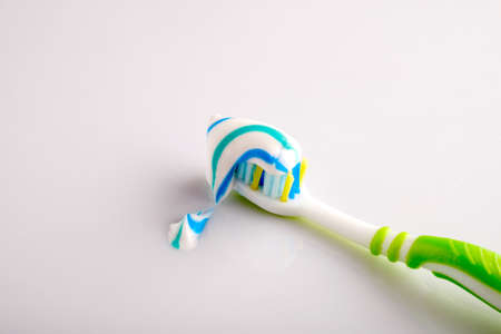A toothbrush with toothpaste on a white background illuminated studio lightの写真素材