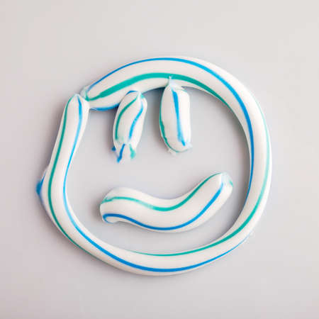 A toothbrush with toothpaste on a white background illuminated studio lightの写真素材