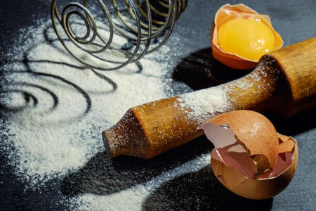 Dough preparation. Baking ingredients: egg and flour on the graphite board.