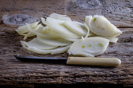 Onions circles, green onion with on board on wooden backgroundの写真素材