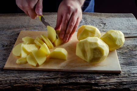 Potatoes on a rustic wooden background, lit by studio lights.の写真素材