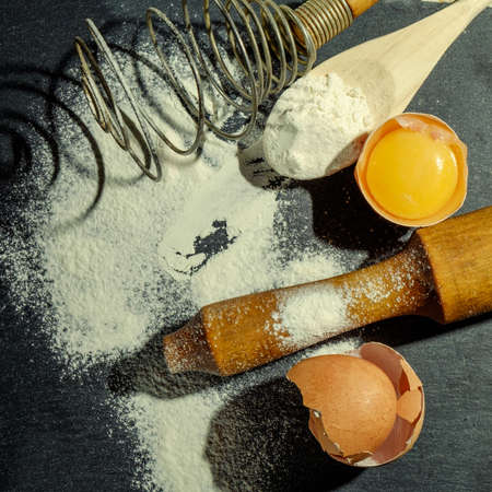 Dough preparation. Baking ingredients: egg and flour on the graphite board.の写真素材
