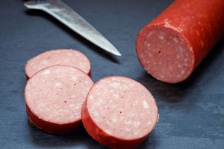 salami sausage on a slate table, lit studio lights.の写真素材