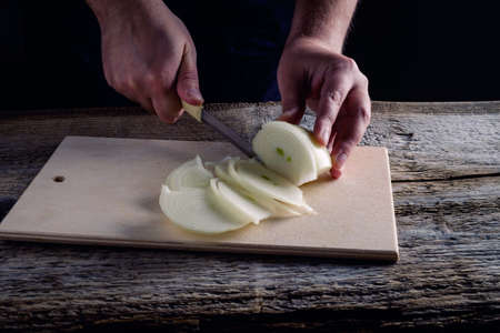 Onions circles, green onion with on board on wooden backgroundの写真素材