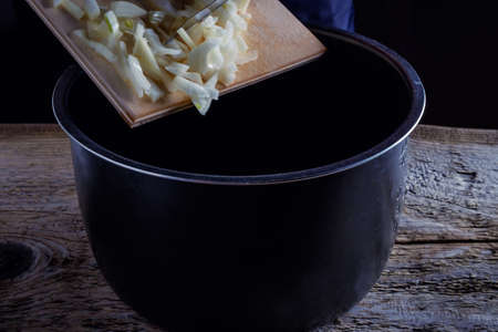 Onions circles, green onion with on board on wooden backgroundの写真素材
