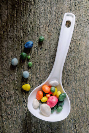Studio photo of red strainer with colorful candy, close-upの写真素材