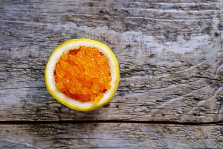Red caviar in a fresh lemon cropped.の写真素材