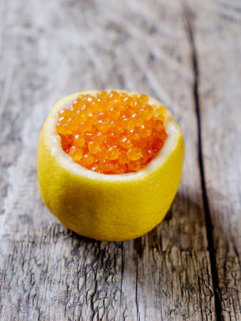 Red caviar in a fresh lemon cropped.の写真素材